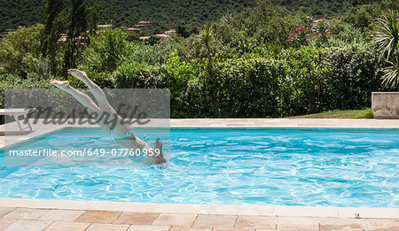 Young women diving into swimming pool, Capoterra, Sardinia, Italy