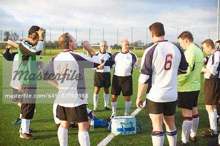 Football players resting and hydrating at half time