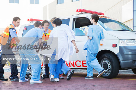 Doctors, nurses, and paramedic examining patient on stretcher