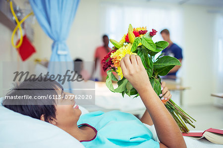 Patient admiring bouquet of flowers in hospital room