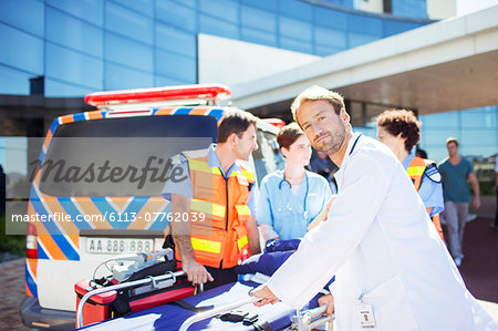 Doctor with paramedics outside hospital