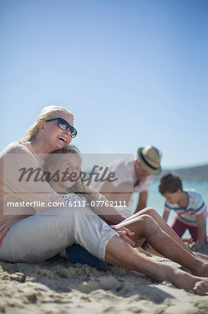 Family sitting together on sandy beach