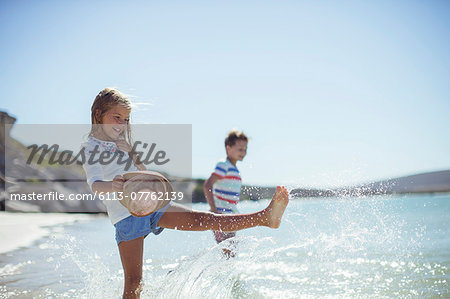 Young girl splashing in water on beach