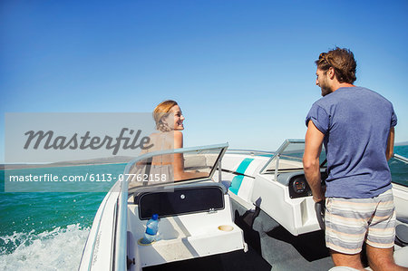 Man steering boat with girlfriend Man steering boat with girlfriend