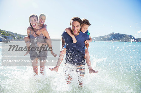 Family running in water on beach
