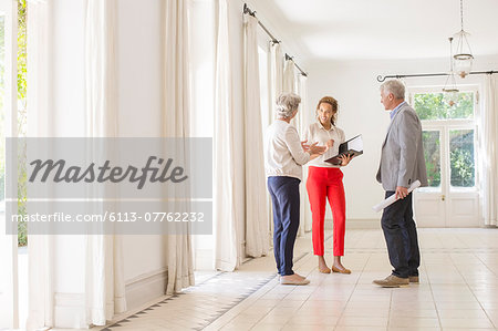 Older couple talking with woman in living space Older couple talking with woman in living space