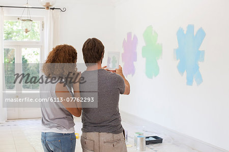 Couple taking picture on wall with digital tablet