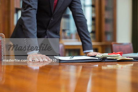 Lawyer leaning on table in chambers