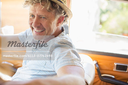 Older man driving car on sunny day