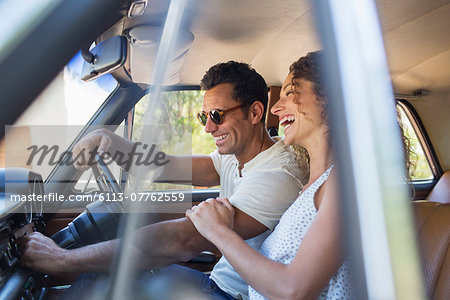 Couple riding in car on sunny day