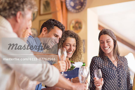 Man pouring drinks to family members