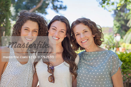 Mother and daughters hugging outdoors