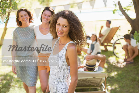 Woman smiling outdoors with family near