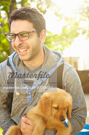 Young man holding labrador puppy