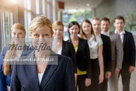 Portrait of businesswoman and business team standing in a row