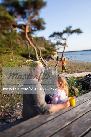 Mother with two children resting on beach, Gotland, Sweden