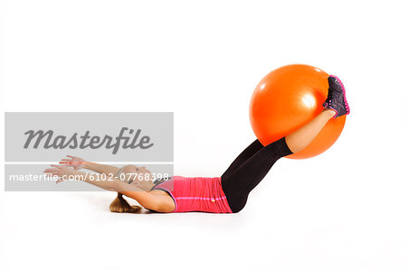 Young woman exercising with ball, studio shot