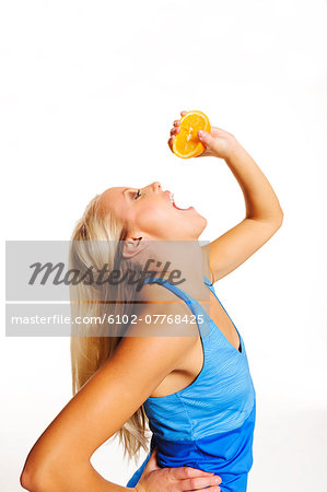 Young woman with orange, studio shot