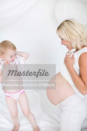 Pregnant mother with daughter, studio shot