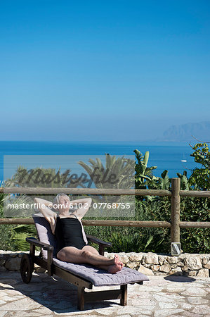 Senior woman sun bathing, Sicily, Italy