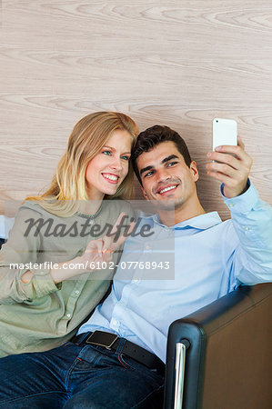 Young couple taking photo of themselves on smartphone, Bangkok, Thailand