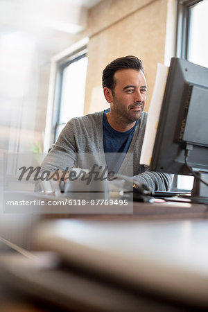 Office life. A man seated at a desk using a computer.