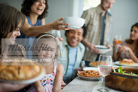 A family gathering for a meal. Adults and children around a table.