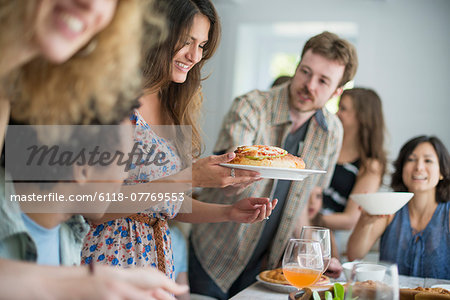 A family gathering for a meal. Adults and children around a table.