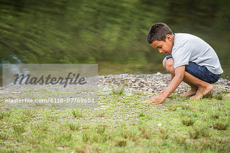 Boy playing by a lake.