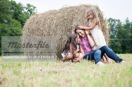 Mother playing outdoors with her daughters.