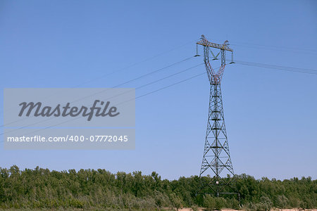 Power transmission tower against blue sky