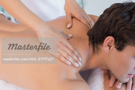 Close up mid section of a man receiving back massage at spa center