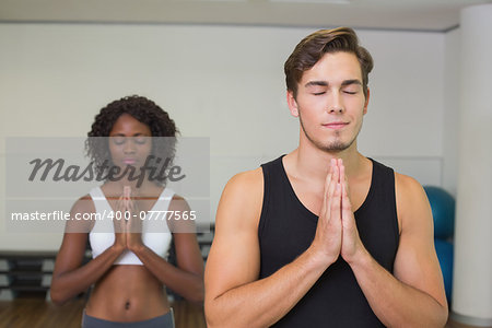 Fit couple standing with hands together at the gym