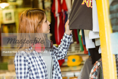 Hipster redhead looking at clothes in the store
