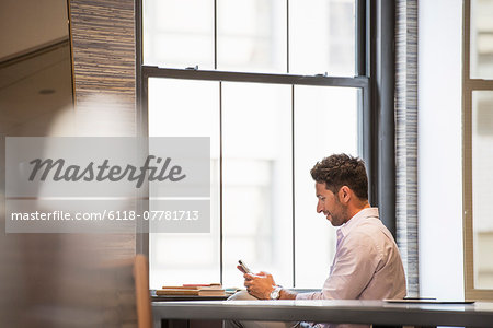 Office life. A man in an office checking his smart phone.