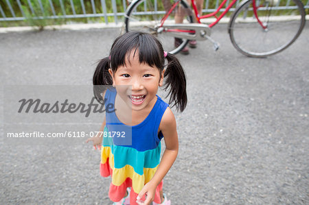 A young girl with pigtails smiling at the camera.