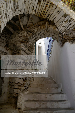 Low angle view of passage over alley with stairs and doorway in mountain village, Greece