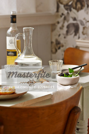 Dining Room Table with Bottle of White Wine, Jug of Water, Corkscrew and Bowls of Blackberries and Duck Eggs