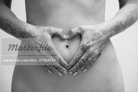 Close-up of Woman with Henna on Hands, Hands in Heart-shape around Belly Button, Studio Shot
