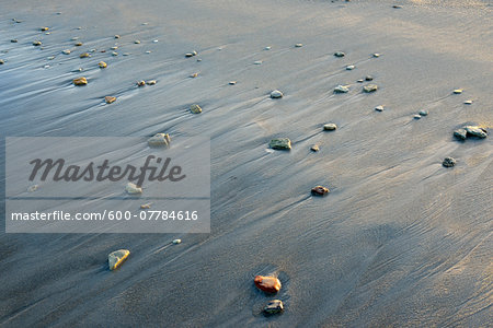 Close-up of pebbles on wet sand, beach on North Sea ocean, Helgoland, Schleswig-Holstein, Germany