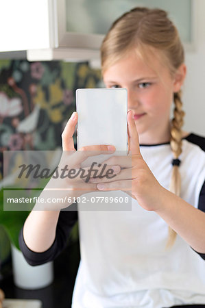 Girl taking picture of herself with smartphone