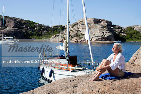 Senior woman resting on cliff