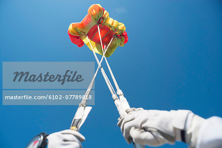 Skydiver in air holding parachute