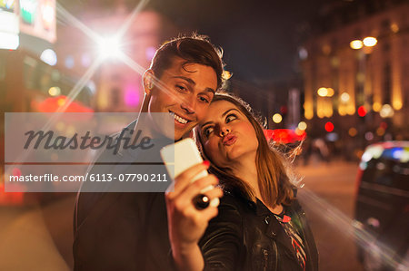 Couple taking picture together with cell phone at night