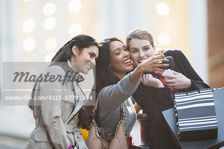 Friends talking picture with cell phone together on city street