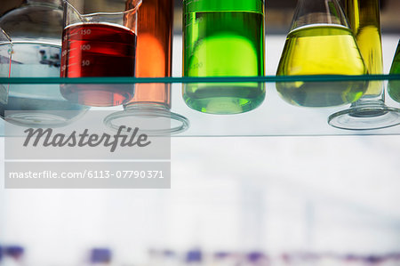 Close up of beakers with solution on shelf in lab