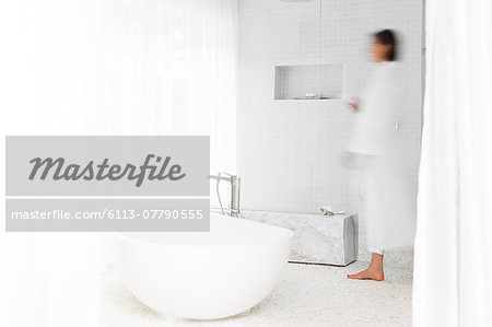 Blurred view of woman walking in modern bathroom