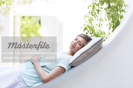 Woman relaxing on pillow outdoors