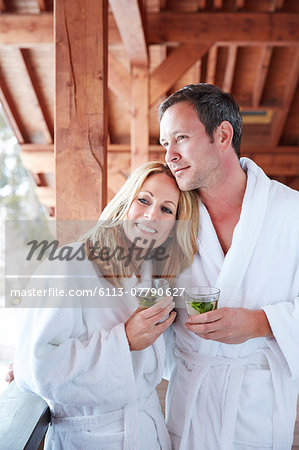 Couple in bathrobes hugging on balcony