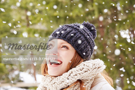 Woman admiring snow falling outside